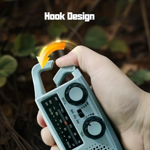 Hand hält Radio mit Hakenfunktion im Freien.