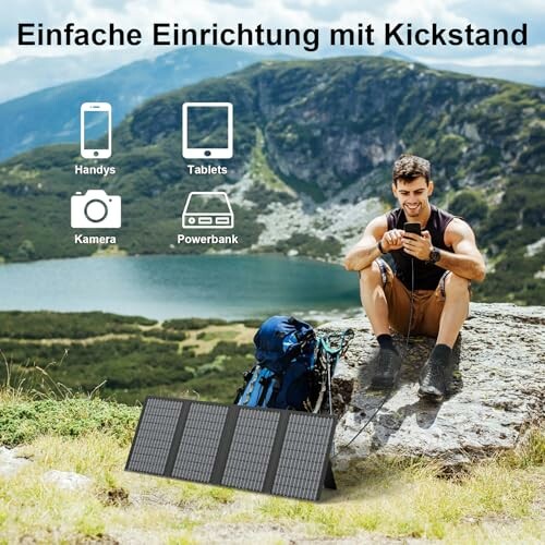 Mann benutzt Solarpanel in den Bergen