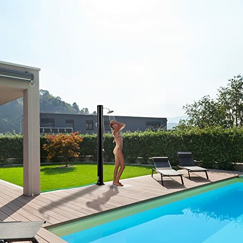 Person duscht neben einem Pool im Freien