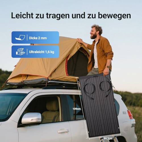 Mann trägt Solarpanel neben Autozelt