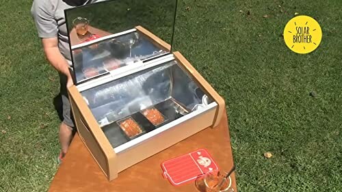 Person nutzt Solarkocher im Freien.